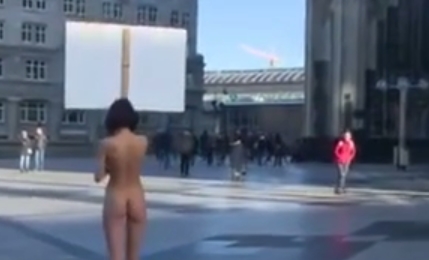 [Explicit] Nude woman stands with sign in Cologne, men interviewed afterward ask, “There was a sign?”